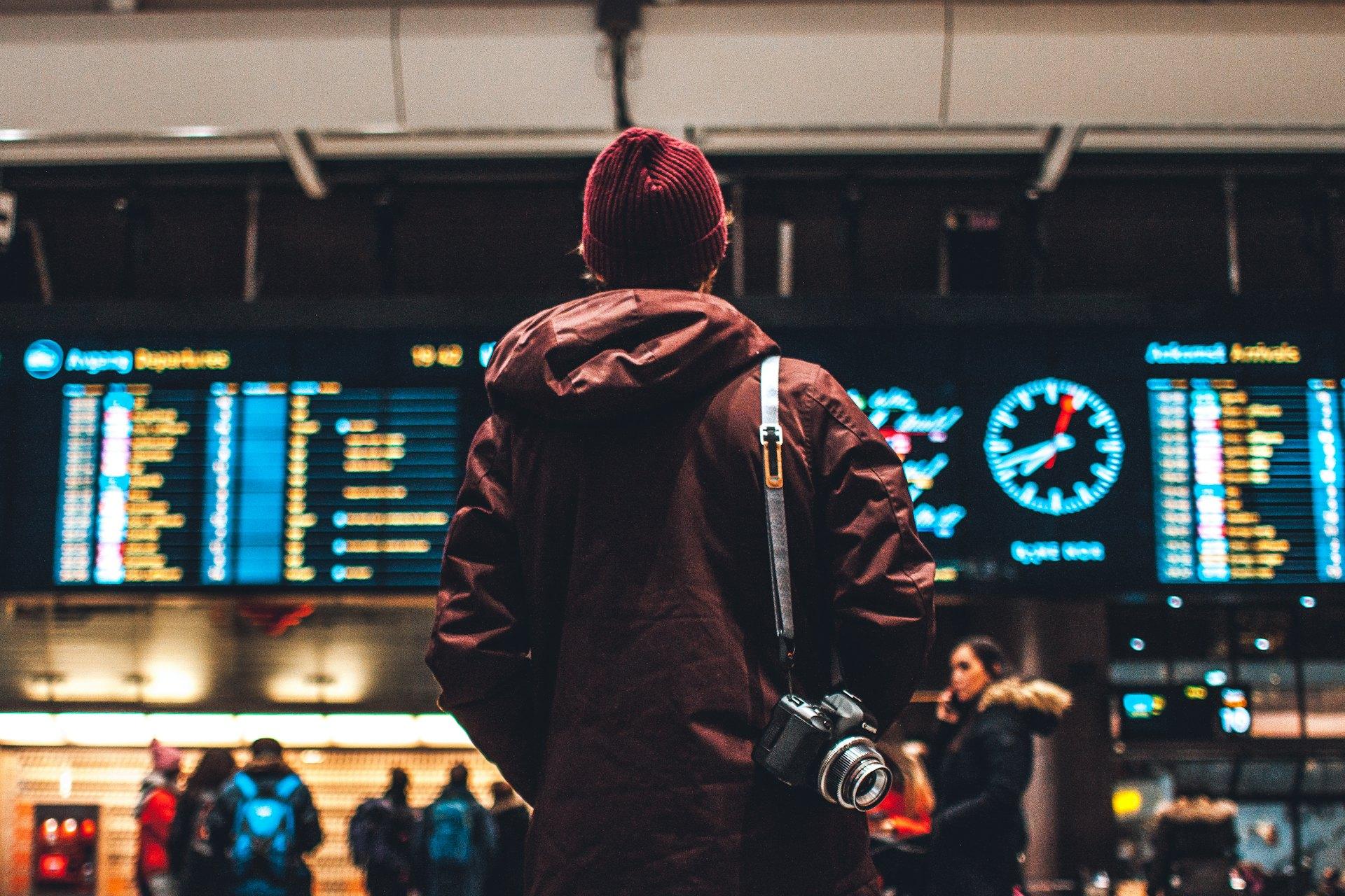 Traveller checking a departures board in an airport terminal