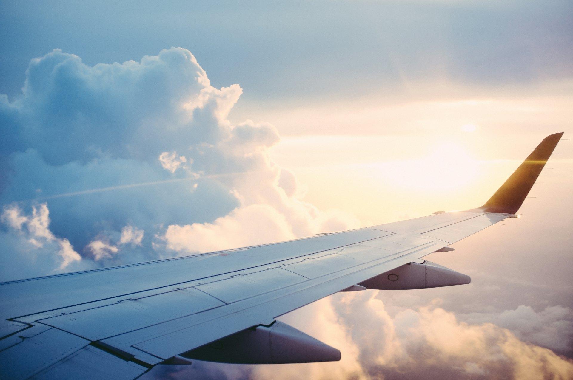 Aircraft wing above a bank of clouds at sunset