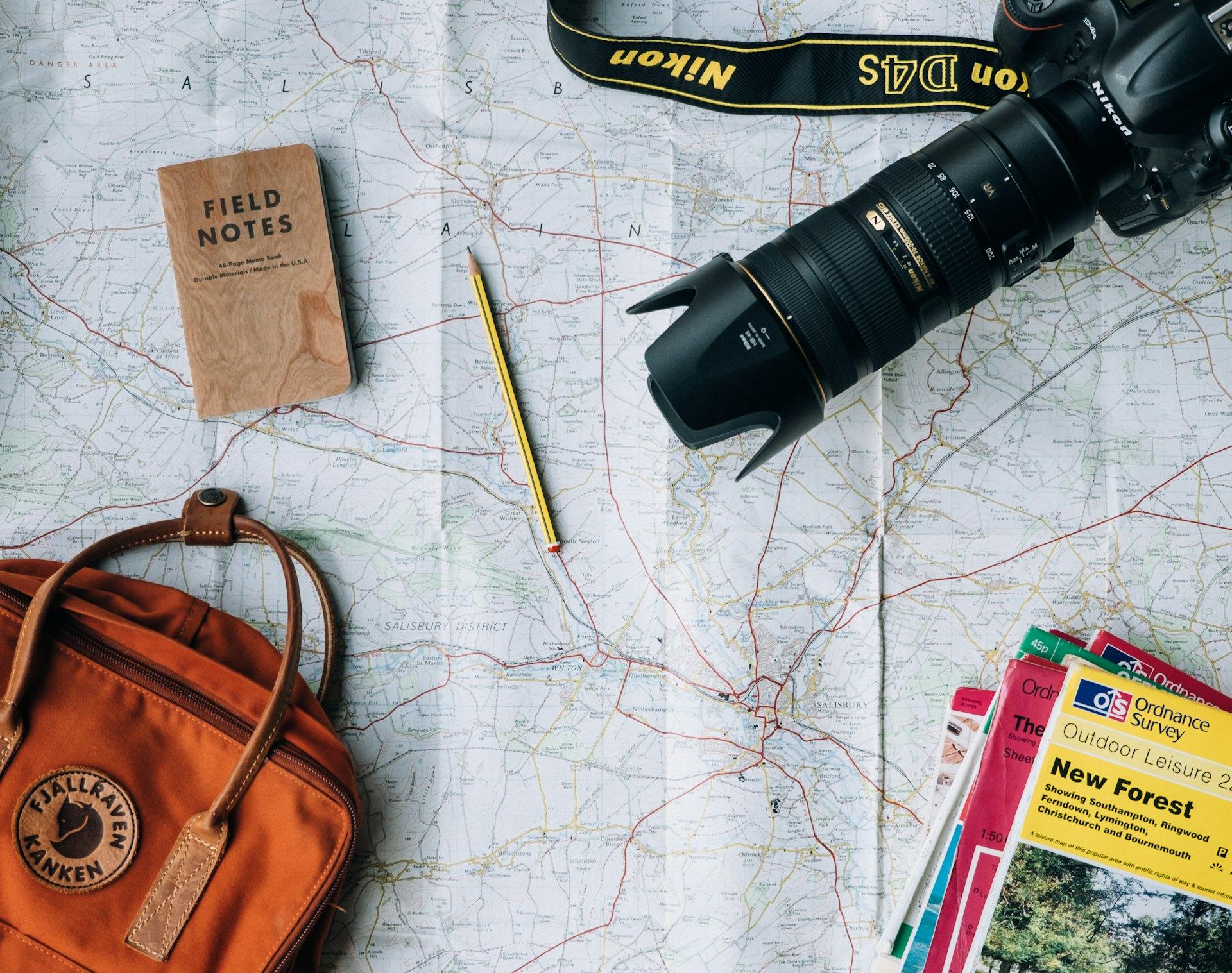 Travel planning desk with a map, notebook and camera